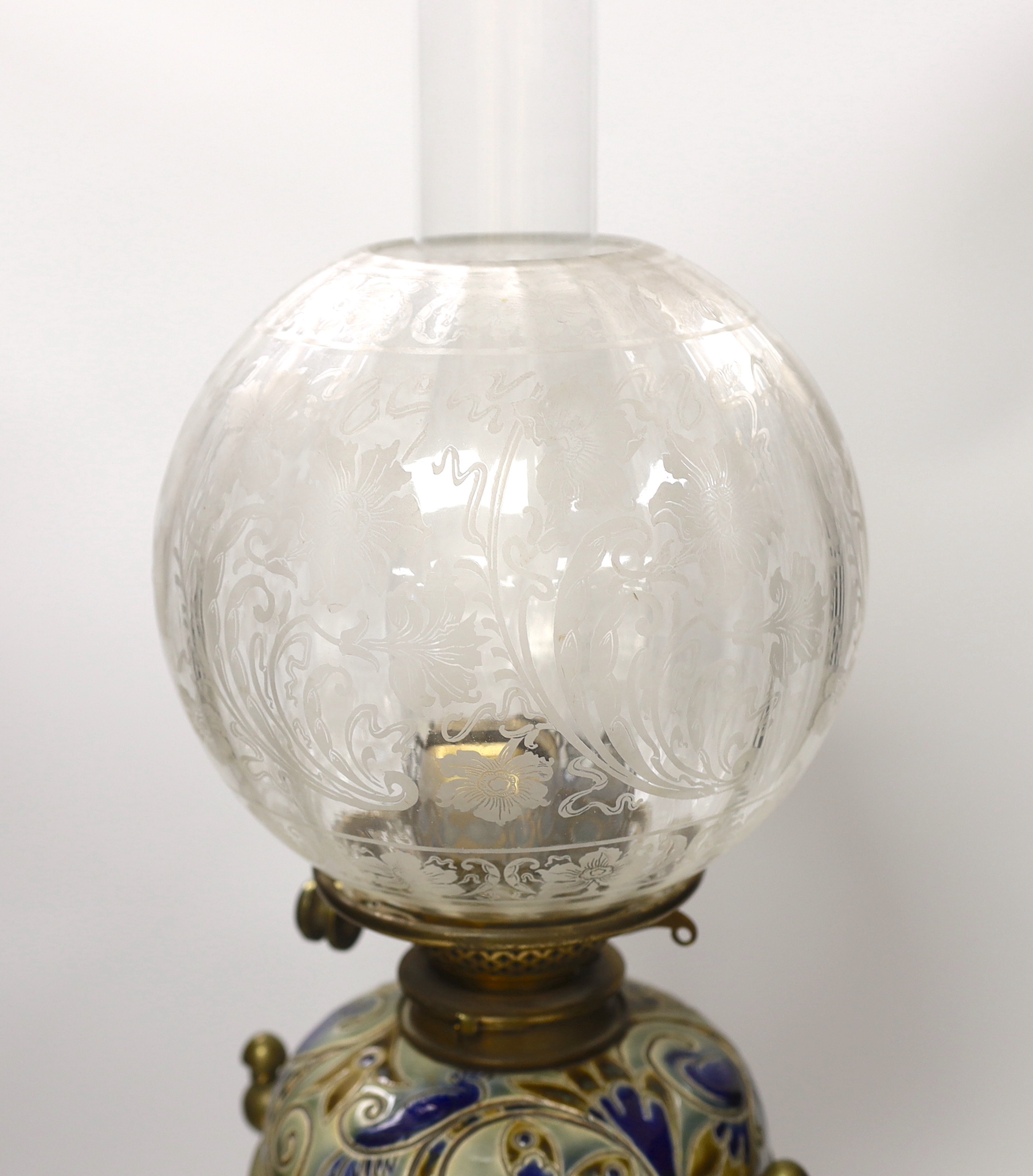 Mark V Marshall for Doulton Lambeth stoneware oil lamp on brass stand with etched glass shade, incised marks to the base of the reservoir, dated 1882, 64cm high overall